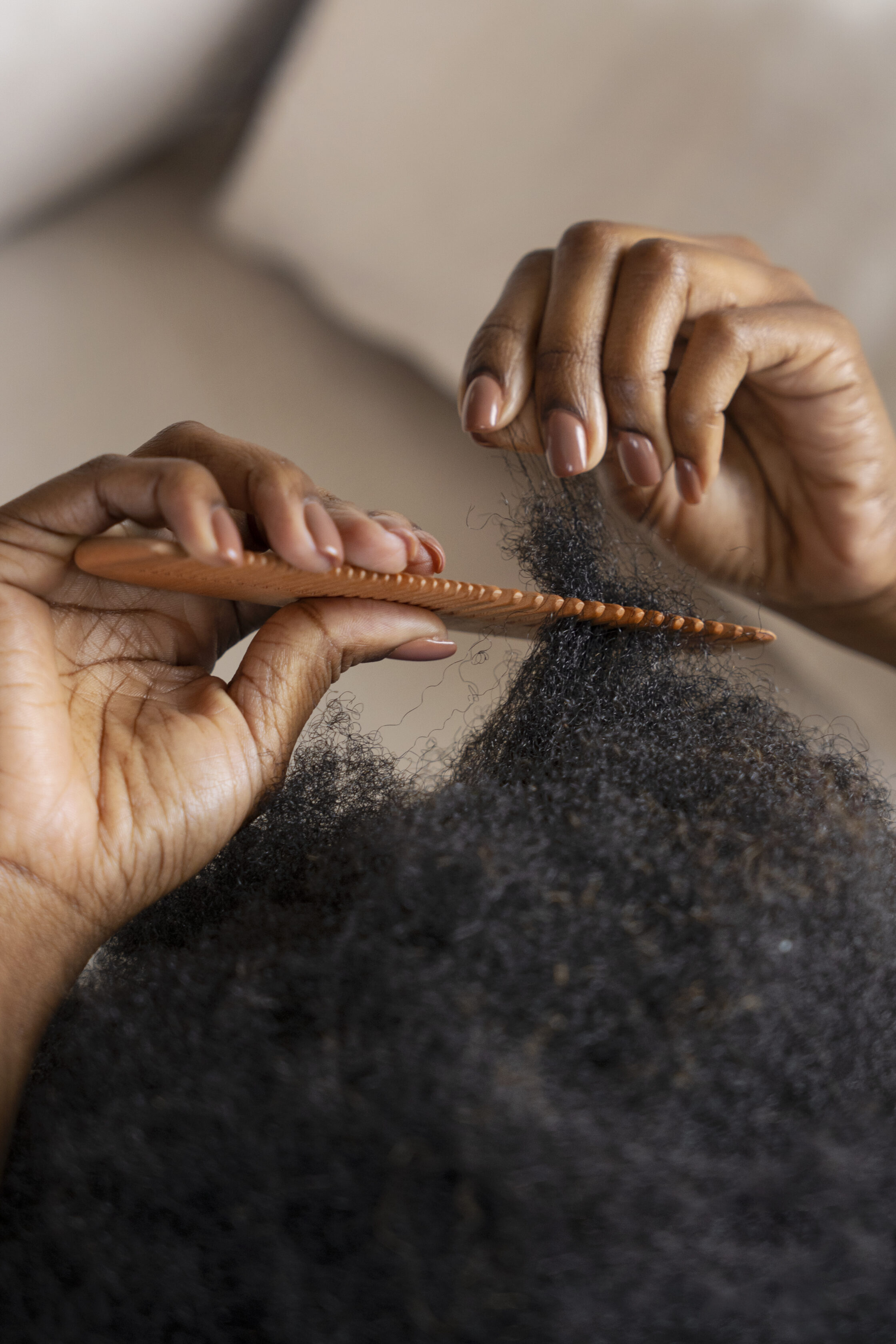 woman-styling-afro-hair-with-comb